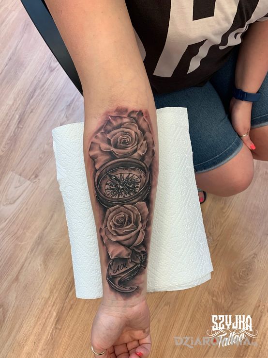 Tatuaż róża wiatrów w otoczeniu róż - miłosne