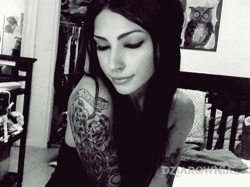 Tatuaż czarnulka z dziarami - kwiaty